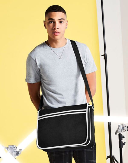 Angled view of the navy and white Bagbase Retro Messenger, showcasing its classic, vintage-inspired design.