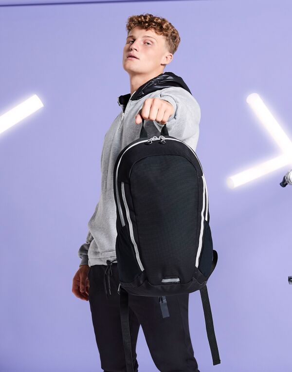 Angled view of the graphite grey and black Bagbase Urban Trail Pack, showcasing its dual-compartment design.