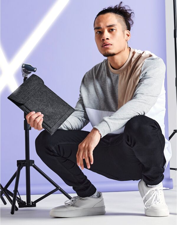 Angled view of the light grey marl Bagbase Felt iPad Slip, showing its slim and snug fit.