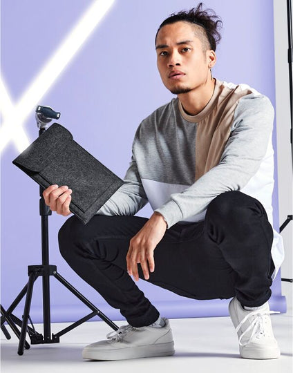 Angled view of the light grey marl Bagbase Felt iPad Slip, showing its slim and snug fit.