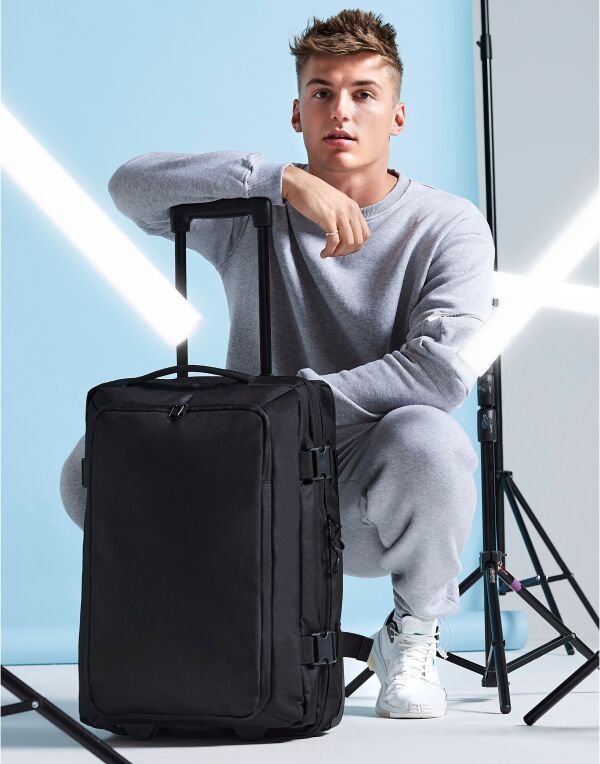 Angled view of the Bagbase Escape Carry-On Wheelie, highlighting its durable wheels and stand-up stability.