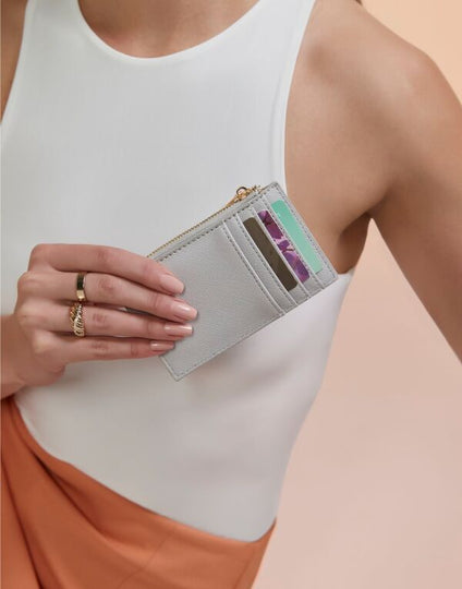 The white Saffiano Boutique Card Holder, a slim and elegant way to carry essential cards.