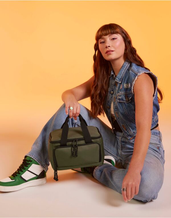 Side angle of the Bagbase across body bag, highlighting its slim profile and multiple zippered compartments.