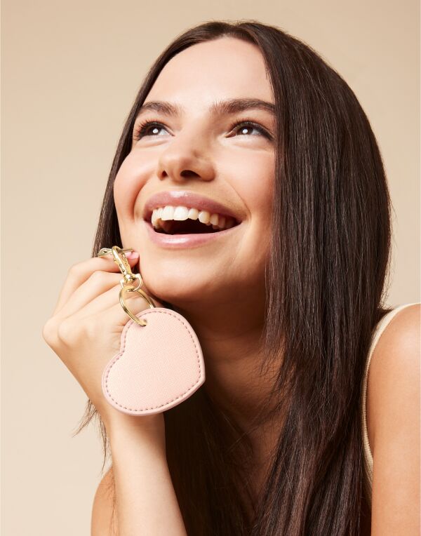 Angled view of the soft pink Bagbase Boutique Heart Key Clip, showcasing its gold metal hardware.