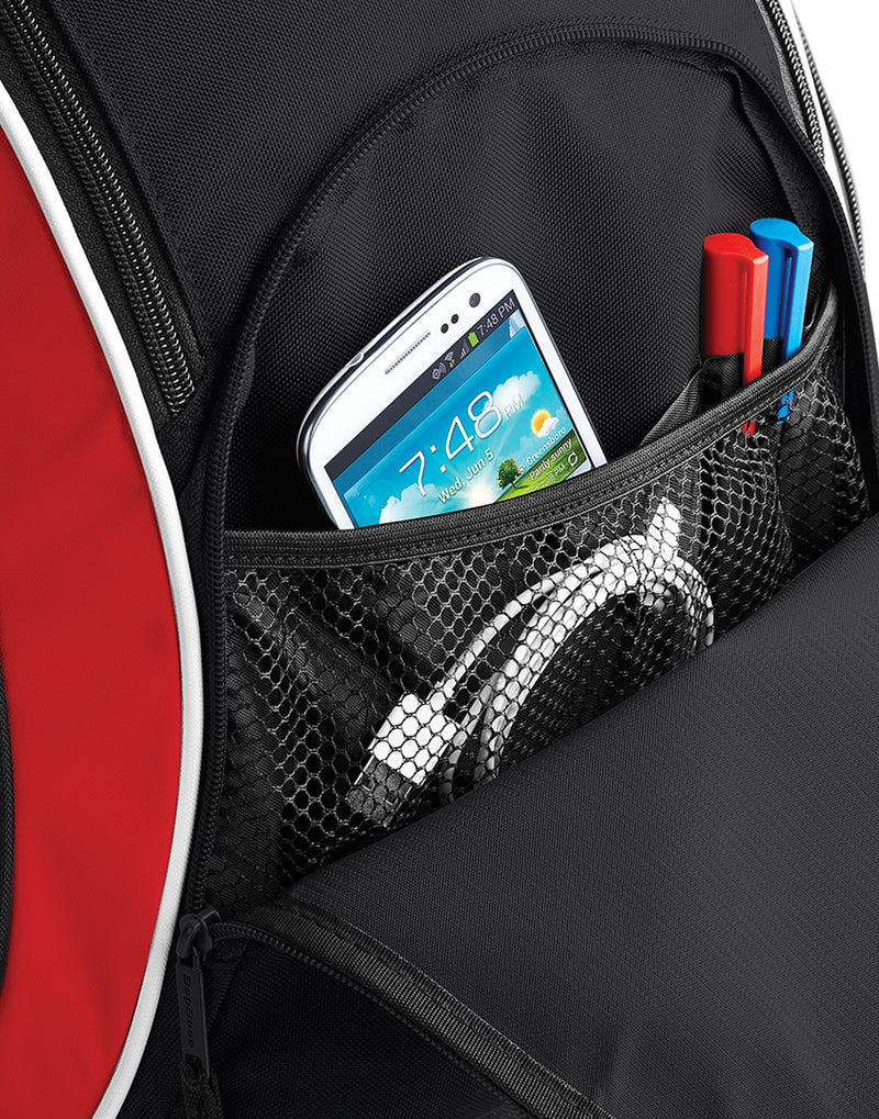 Side profile of the classic navy Bagbase Teamwear Backpack, illustrating its depth and carrying capacity.
