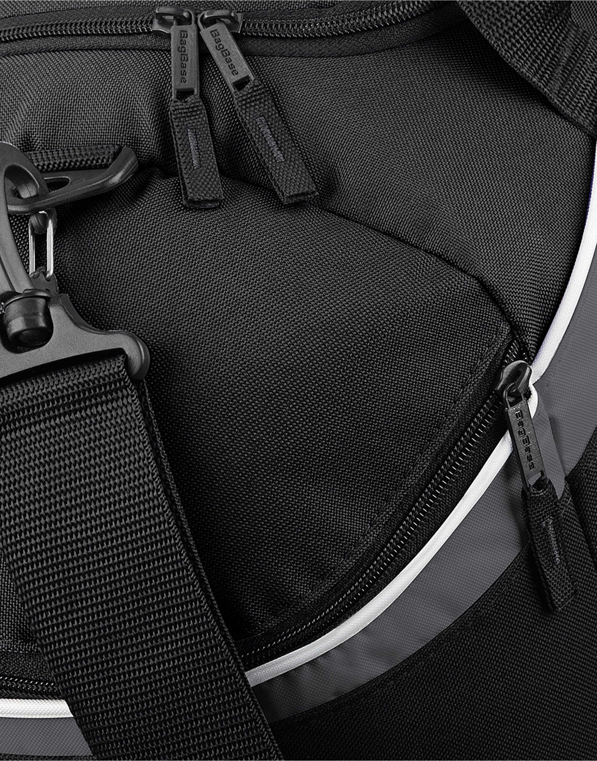 A person carrying the navy Bagbase Teamwear Holdall, demonstrating its size and portability.