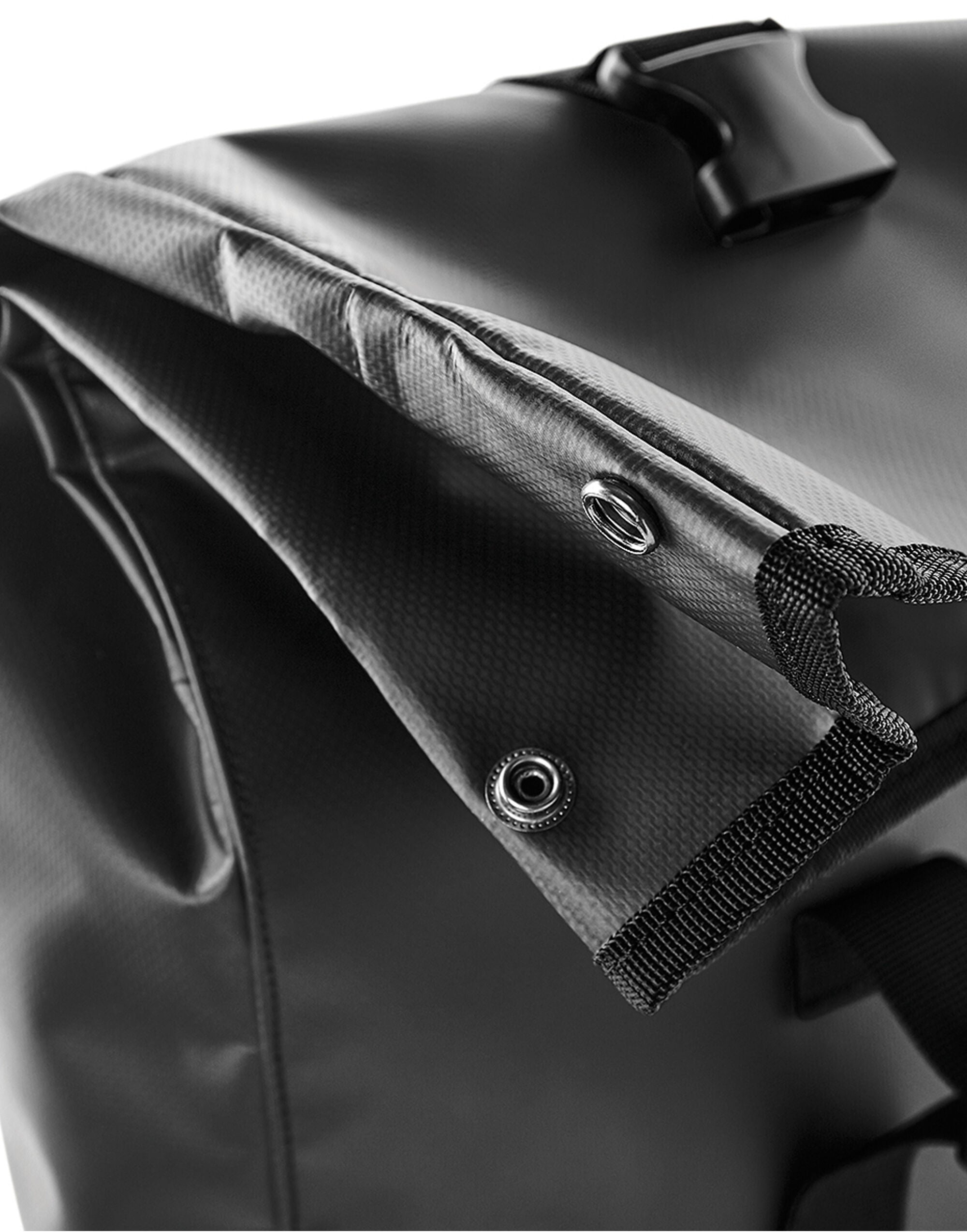 Black waterproof tarpaulin roll-top backpack.